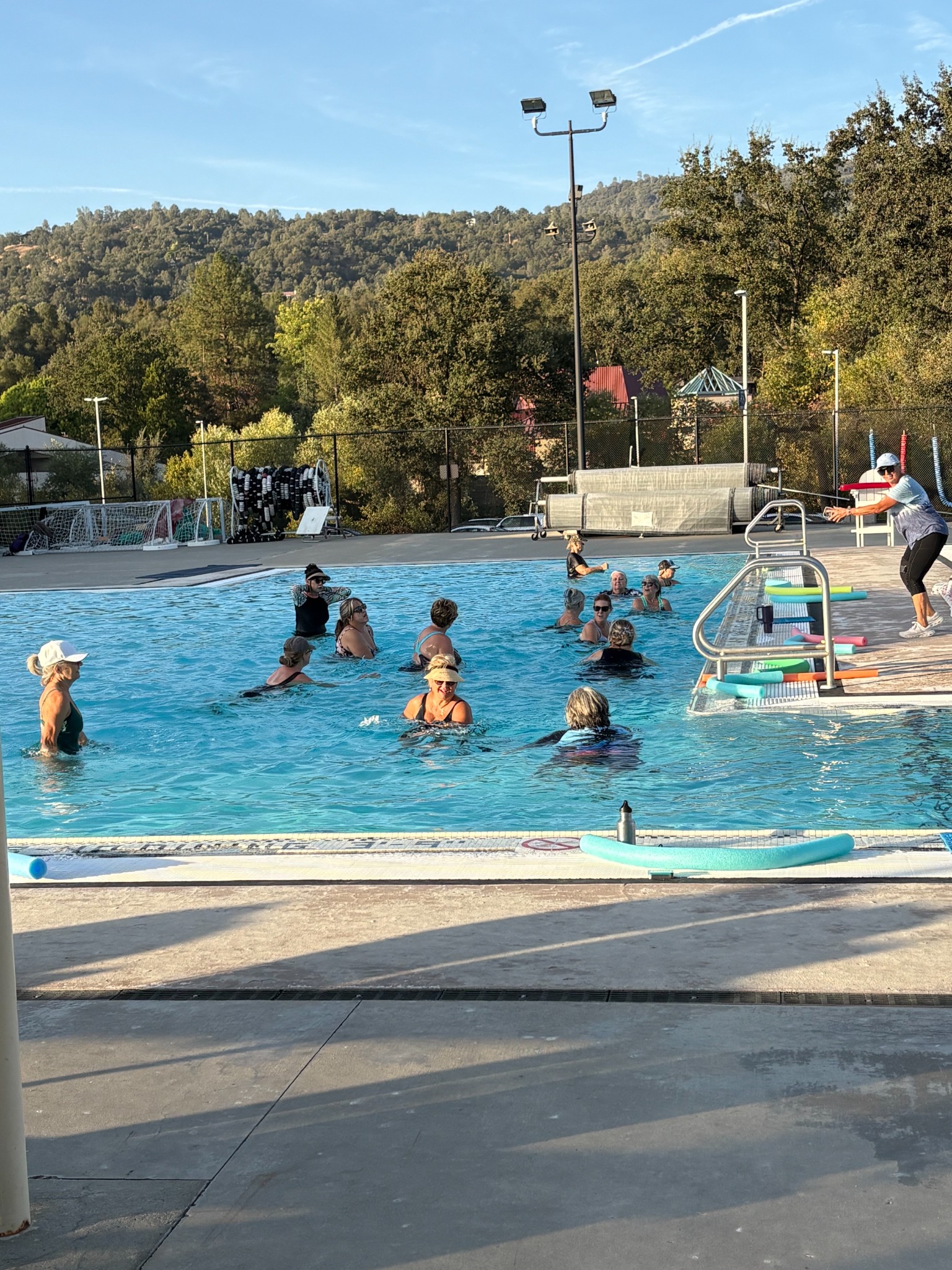 Coach Rae leading a Clouds Rest Aqua Fitness class from the pool deck