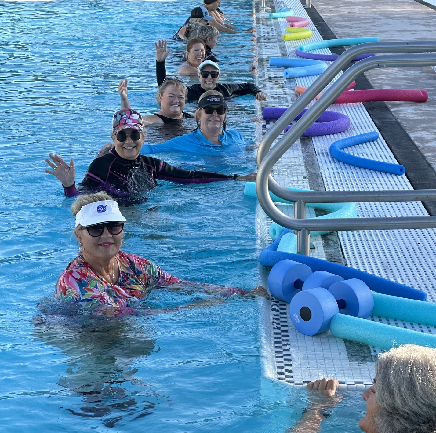 Smiling Clouds Rest aqua fitness members waving from the pool