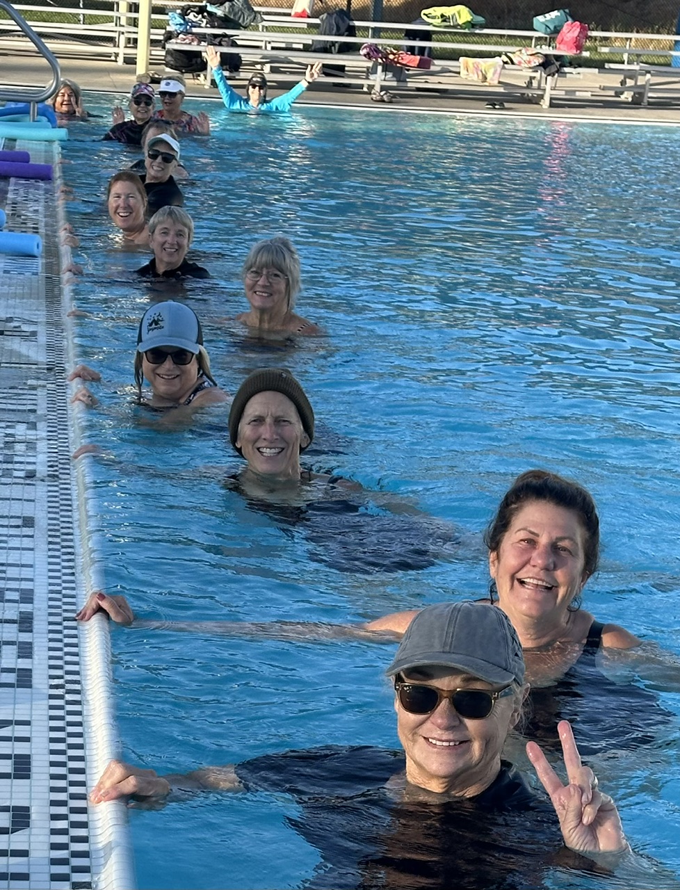 Clouds Rest aqua fitness members smiling together along the pool wall